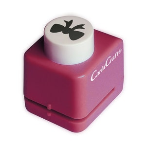 May include: A pink plastic paper punch with a white top. The top has a black silhouette of a bow. The punch is labelled "CarlaCraft".