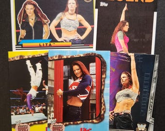 May include: A collection of trading cards featuring a female wrestler, Lita. The cards are from the WWE Absolute Divas series and the Topps Legend series. The cards feature different photos of Lita in various wrestling poses.