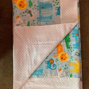 Baby boy receiving blanket with jungle animal design.