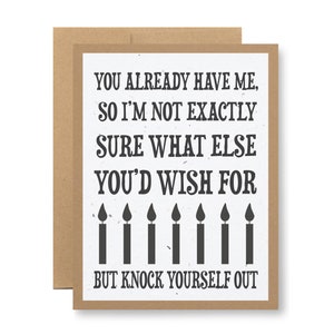 May include: A white card with black text that reads "You already have me, so I'm not exactly sure what else you'd wish for, but knock yourself out." There are six black candle flames above the text.