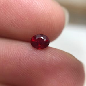 Safira vermelha tratada com berílio, 0,42 quilates, lapidação oval de 4,6 x 3,6 mm, gema solta sem montagem.