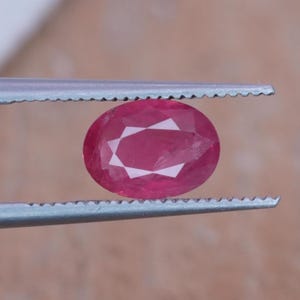Rubi de 1,10 quilates, lapidação oval de 7,5 x 5,45 mm, vermelho rosado.