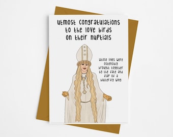 May include: A white card with a humorous illustration of a person wearing a white robe and a crown. The text on the card reads "Utmost congratulations to the love birds on their nuptials whose lives were ostensibly brought together by the fate and flap of a butterfly wing."