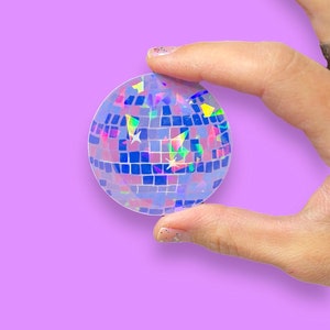 May include: A holographic sticker of a disco ball with a blue, purple, and green iridescent finish.