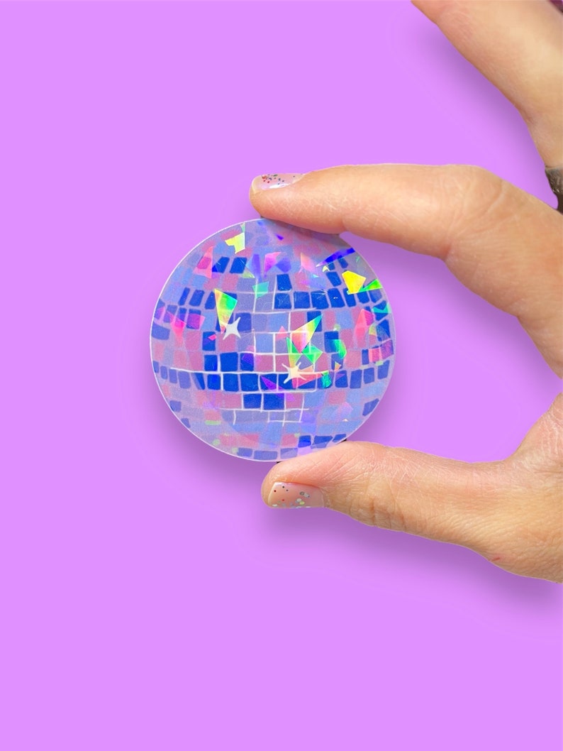 May include: A holographic sticker of a disco ball with a blue, purple, and green iridescent finish.