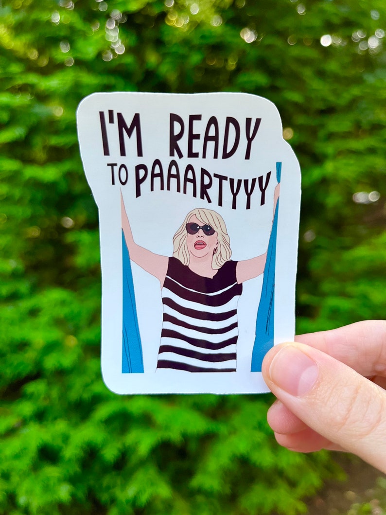 May include: A white sticker with a cartoon illustration of a woman with blonde hair wearing sunglasses and a black and white striped shirt. The woman is holding onto two blue curtains. The text on the sticker reads "I'm ready to paaartyyy".