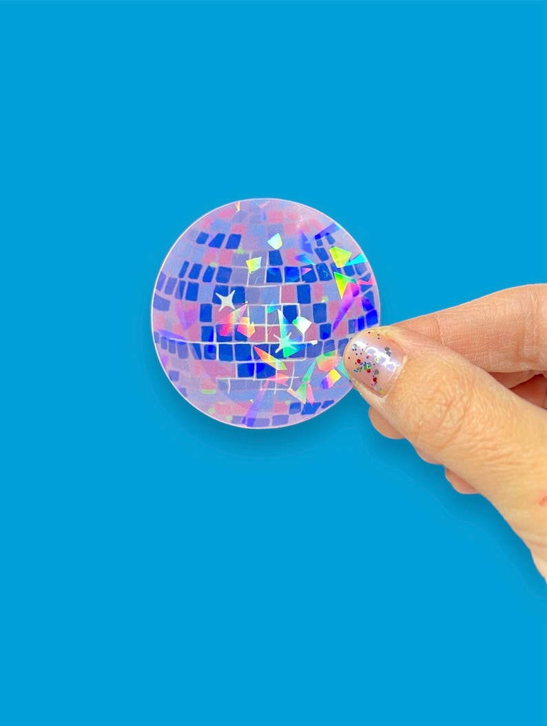 May include: A clear iridescent sticker with a disco ball design. The sticker has a holographic finish with a variety of colors, including blue, pink, and green.