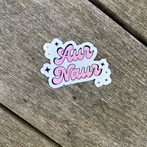 Peut inclure: Autocollant rose et noir avec le texte "Awr Naur" dans une police r&eacute;tro. L'autocollant a de petites &eacute;toiles blanches autour du texte.