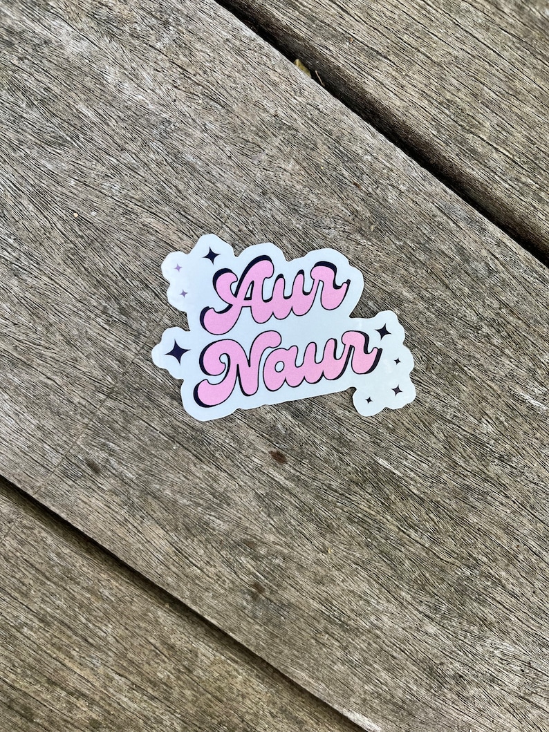 Peut inclure: Autocollant rose et noir avec le texte "Awr Naur" dans une police r&eacute;tro. L'autocollant a de petites &eacute;toiles blanches autour du texte.