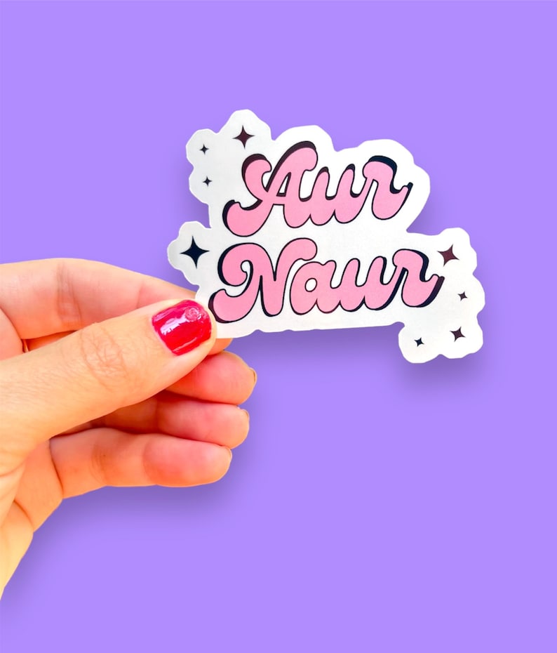 Peut inclure: Un autocollant rose et blanc avec le texte "Awr Naur" dans un style de police r&eacute;tro. L'autocollant a de petits accents d'&eacute;toiles.