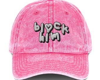 Könnte beinhalten: Rosa vintage gewaschene Denim Baseballkappe mit dem Text "block him" in schwarzen und weißen Stickbuchstaben.