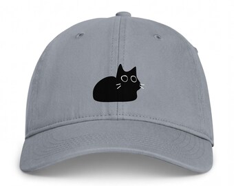 Könnte beinhalten: Eine graue Baseballkappe mit einer mittigen Grafik einer schwarzen Katzensilhouette. Das Katzendesign zeigt einfache weiße Umrisse für die Augen und drei dünne weiße Linien auf jeder Seite des Gesichts, die die Schnurrhaare darstellen.