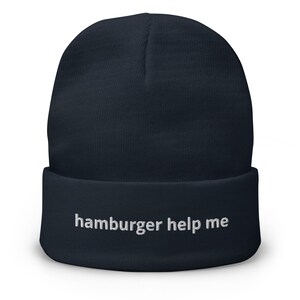 May include: A navy blue beanie with the text "hamburger help me" embroidered in white on the front.