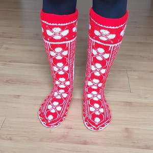 May include: Red and white knitted knee-high socks with a floral pattern.