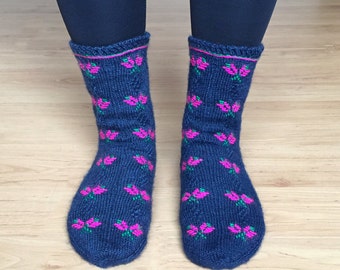 May include: A pair of blue knitted socks with a pink and green floral pattern.