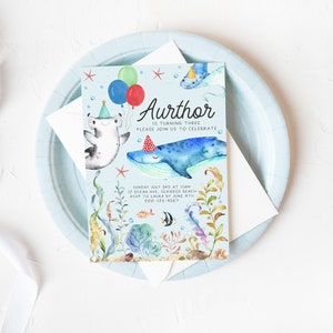 May include: A blue and green watercolor invitation with a whale, a hammerhead shark, and a starfish. The text on the invitation reads "Aurthor is turning three, please join us to celebrate. Sunday July 3rd at 1:00 pm, 12 Ocean Ave, Seaweed Beach, RSVP to Laura by June 4th, 000-123-4567."