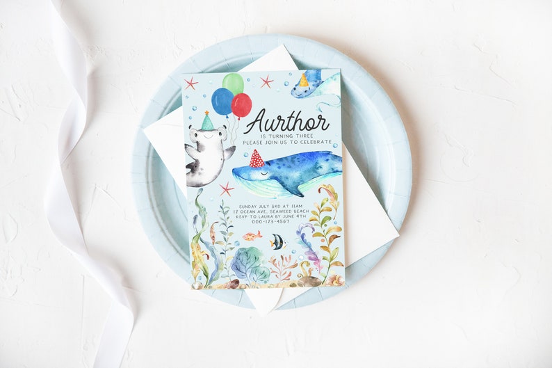 May include: A blue and green watercolor invitation with a whale, a hammerhead shark, and a starfish. The text on the invitation reads "Aurthor is turning three, please join us to celebrate. Sunday July 3rd at 1:00 pm, 12 Ocean Ave, Seaweed Beach, RSVP to Laura by June 4th, 000-123-4567."