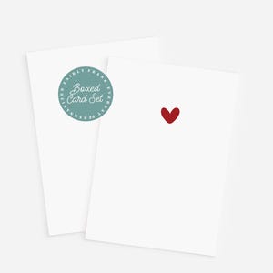May include: A set of white cards with a red heart on one card. The other card has a teal circular sticker with the text "Boxed Card Set". The cards are for everyday personalized use.