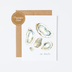 Op de afbeelding: Een witte wenskaart met een aquarelillustratie van vier oesters in blauwe, grijze en beige tinten. De tekst "aw, shucks" staat in kleine blauwe letters rechtsonder gedrukt. Een bruine envelop bevindt zich achter de kaart.