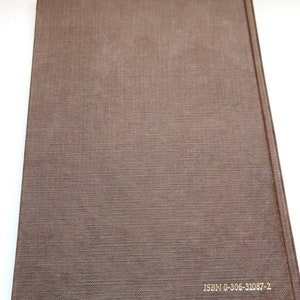 Puede incluir: Un libro de tapa dura marr&oacute;n con una cubierta texturizada. El lomo es visible y el texto "ISBN 0-306-31087-2" est&aacute; impreso en dorado. La cubierta del libro tiene un patr&oacute;n sutil y tejido.