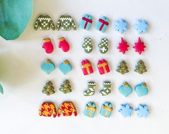 May include: A set of 18 pairs of Christmas-themed stud earrings. The earrings are made of polymer clay and feature various designs, including snowflakes, Christmas trees, ornaments, mittens, sweaters, and gift boxes. The earrings are in shades of green, red, blue, and gold.