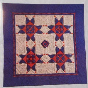 May include: A quilt pattern for a Feathered Stars quilt. The pattern includes instructions for paper foundation piecing. The quilt is made with blue, red, and white fabric. The pattern includes a contact address and phone number for Quilt Directions.