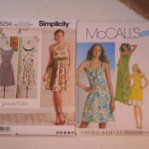 Op de afbeelding: Twee naaipatronen enveloppen, een voor Simplicity patroon 8294 en de andere voor McCall's patroon M6071. Het Simplicity patroon toont een vrouw die een groen-witte bloemenjurk draagt. Het McCall's patroon toont een vrouw die een blauw-witte bloemenjurk draagt.