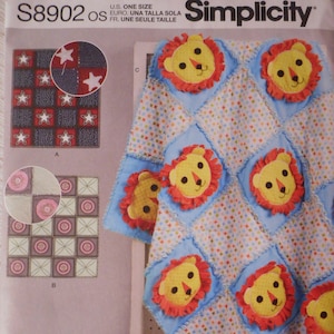 Può includere: Modello di cucito Simplicity numero S8902 OS per una copertina per neonato a tema leone. Il modello include istruzioni per realizzare una trapunta patchwork con applicazioni di leone. La trapunta è blu con leoni gialli e arancioni e uno sfondo bianco con piccoli punti colorati.