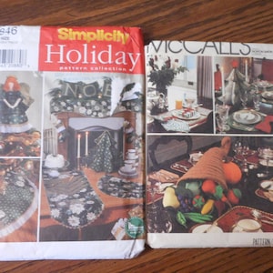 May include: Two sewing patterns for holiday crafts. The Simplicity pattern features a Christmas tree topper and table runner. The McCall's pattern features a cornucopia and table runner.