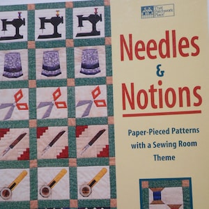 Puede incluir: Un libro titulado "Needles & Notions" con una portada amarilla y un diseño de colcha colorido con imágenes de temática de costura. El diseño de la colcha incluye máquinas de coser, dedal, tijeras, reglas, agujas y alfileteros. El libro es de Jaynette Huff y presenta patrones de patchwork de papel con un tema de sala de costura.