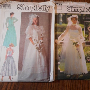 May include: Two Simplicity sewing patterns for wedding dresses. The pattern on the left is for a long, white dress with a lace trim and a veil. The pattern on the right is for a shorter, white dress with a lace trim and a veil. Both patterns feature a model wearing the dress and a smaller image of a model wearing a different dress.