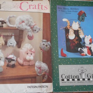 Puede incluir: Dos libros de patrones de manualidades. La portada izquierda presenta varias manualidades de animales de peluche, incluyendo gatos, ovejas y conejos. La portada derecha muestra un gato en un cubo y un gato sentado. El texto "Crafts" es visible en la portada izquierda.