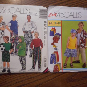 May include: Two sewing pattern packages for children's clothing. The left package is McCall's 5484 and includes patterns for pants, a shirt, and a jacket. The right package is Easy McCall's 3193 Kidstuff and includes patterns for shorts and a shirt.