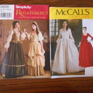 Op de afbeelding: Twee naaipatronen voor Renaissance-kostuums. Het Simplicity-patroon is voor een groene en gouden jurk met een witte kantversiering. Het McCall's-patroon is voor een witte jurk met een kantversiering en een rode jurk met een kantversiering.