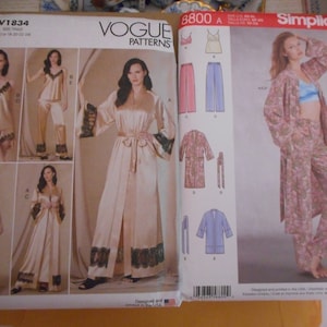 May include: Two sewing patterns for sleepwear. The pattern on the left is Vogue Patterns V1834 and features a long robe and pants. The pattern on the right is Simplicity 8800 and features a robe and pants with a floral print.