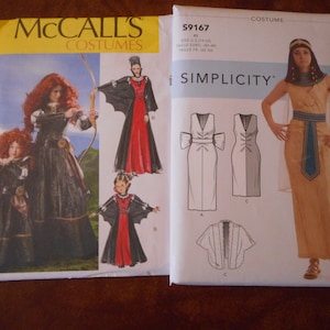 Puede incluir: Dos patrones de costura para disfraces. El primer patrón es de McCall's y presenta un vestido rojo y negro con una capa. El segundo patrón es de Simplicity y presenta un vestido dorado y azul con una capa.