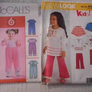 Puede incluir: Dos patrones de costura para ropa de niños. El primer patrón es de McCall's y presenta seis estilos diferentes de monos. El segundo patrón es de New Look y presenta una blusa blanca con pantalones rosas, una blusa a rayas con pantalones rojos y una capa azul.
