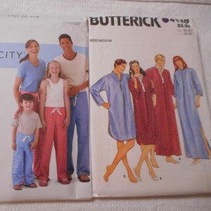 May include: Two sewing pattern packages, one from Simplicity and one from Butterick. The Simplicity pattern shows a family of four wearing pajamas. The Butterick pattern shows four people wearing long nightgowns. The Simplicity pattern number is 59132. The Butterick pattern number is 9126.
