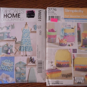 May include: Two sewing patterns, one for home decorating and one for sewing accessories. The home decorating pattern shows a blue and white apron, storage bins, and hangers. The sewing accessories pattern shows a variety of bags and containers, including a sewing machine cover.