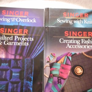 May include: Four Singer sewing books with colourful covers. The titles are "Sewing with Overlock", "Sewing with Knits", "Quilted Projects & Garments", and "Creating Fashion Accessories".
