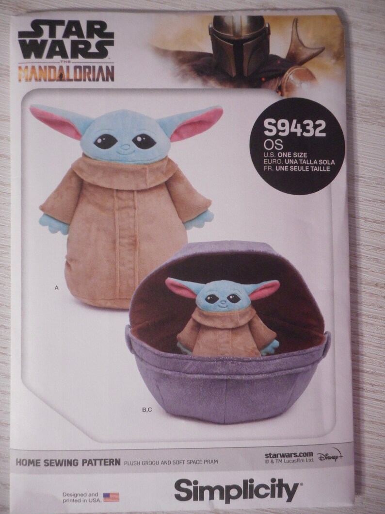 May include: A Simplicity sewing pattern for a plush Grogu toy and a soft space pram. The pattern is for one size and includes instructions for making both the toy and the pram. The pattern is from Star Wars: The Mandalorian.