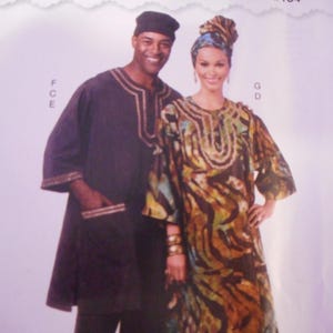 May include: Image of two people wearing traditional African attire. The man wears a dark tunic with gold trim, a matching cap, and dark pants. The woman wears a patterned dress with a matching head wrap and gold bracelets. The background is a light purple.