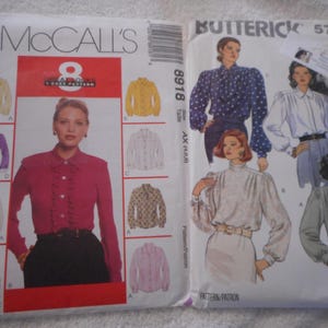 May include: Two sewing pattern packages for blouses. The McCall's pattern is for a ruffled blouse with long sleeves and buttons. The Butterick pattern is for a blouse with long sleeves and a gathered neckline. Both patterns feature women wearing the blouses.