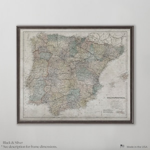 May include: Framed vintage map of Spain and Portugal, featuring detailed geographical information. The map is in a dark frame and has a neutral color palette. The text "SPAIN & PORTUGAL" is visible. Made in the USA.
