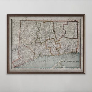May include: An antique map of Connecticut with county borders and town names. The map is printed in brown, black, and red ink on a white background. The map is framed in a brown wooden frame.