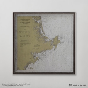May include: A framed nautical chart of the North Shore of Massachusetts, with a distressed dark silver hardwood frame. The chart features detailed coastlines, depths, and navigational information. The text "NORTH SHORE" is visible. Made in the USA.