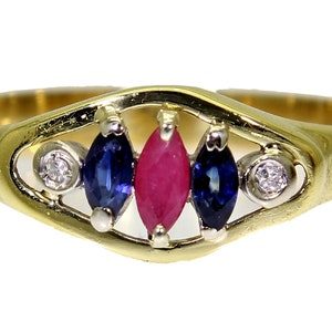以下が含まれることがあります： 繊細なオープンデザインにルビーと2つのサファイアがセットされたゴールドリング。リングは2つの小さなダイヤモンドで飾られています。