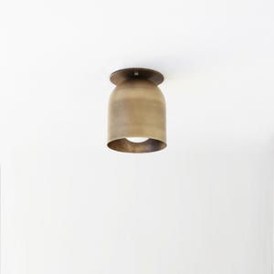 May include: A brass ceiling light fixture with a bell-shaped shade.