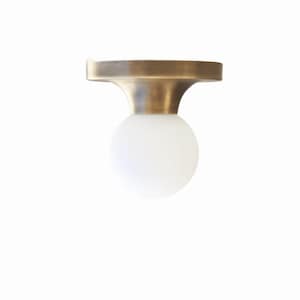 May include: A modern flush mount ceiling light fixture. It features a round, frosted white glass globe shade suspended from a brass-colored metal base. The base has a flat, circular top and a curved, conical neck.