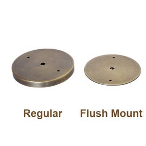 May include: Two round metal ceiling light fixture mounting plates. The plate on the left is labeled "Regular" and the plate on the right is labeled "Flush Mount".
